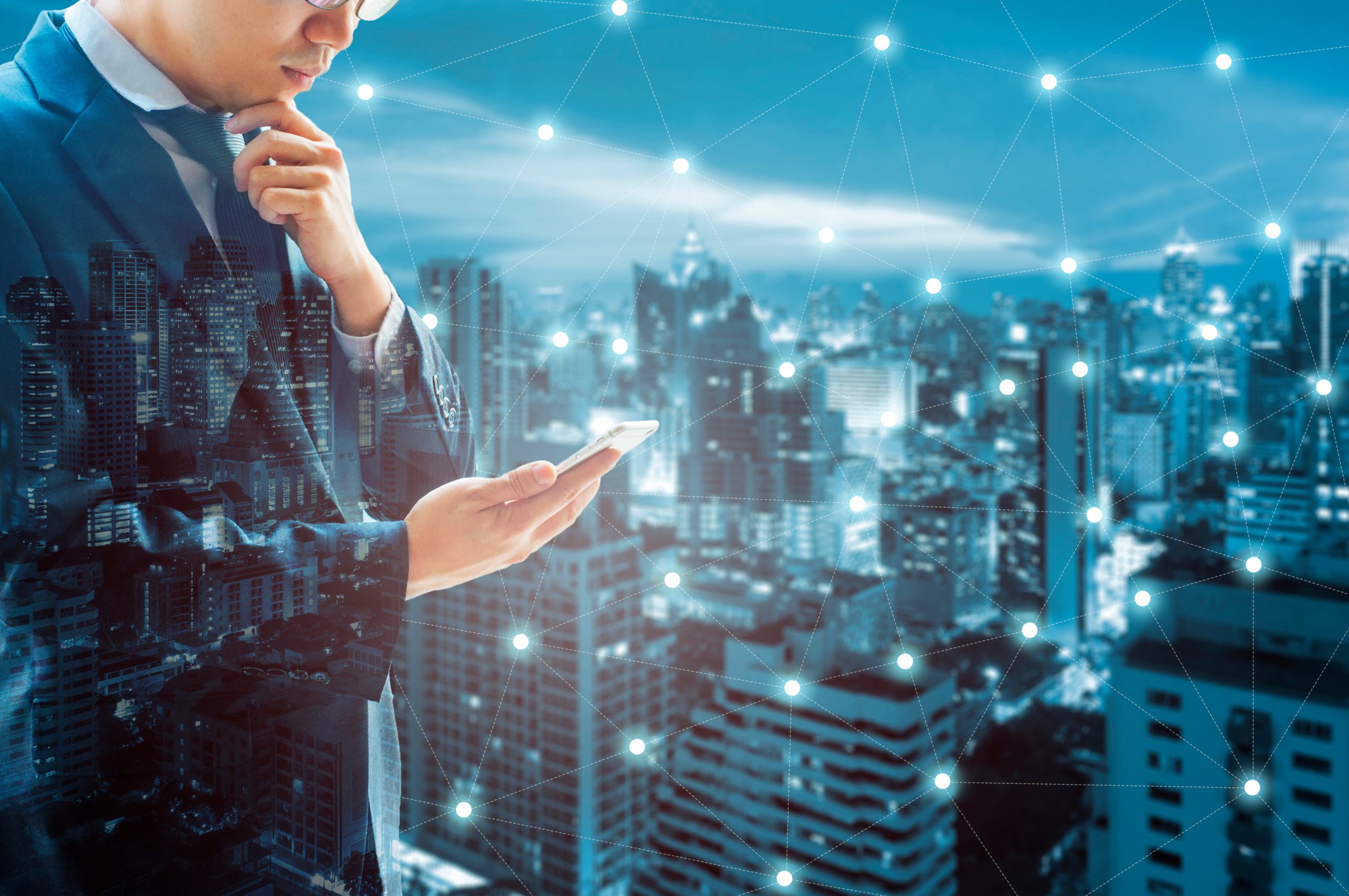 Double exposure of professional businessman connected internet a Double exposure of professional businessman connected internet and wireless network with his smart phone and city of business background in business trading and technology concept